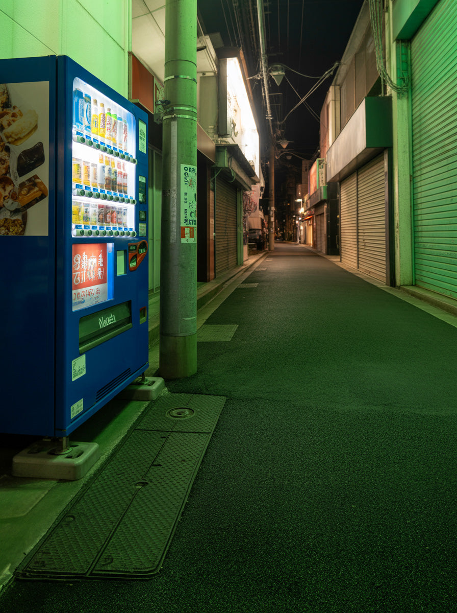 Neon lit narrow alley with vending machine at night