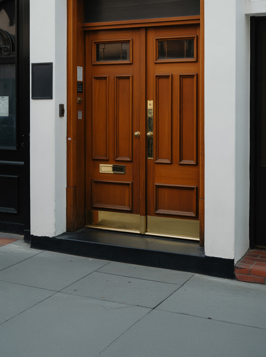 Classic wooden double door with brass details on urban facade