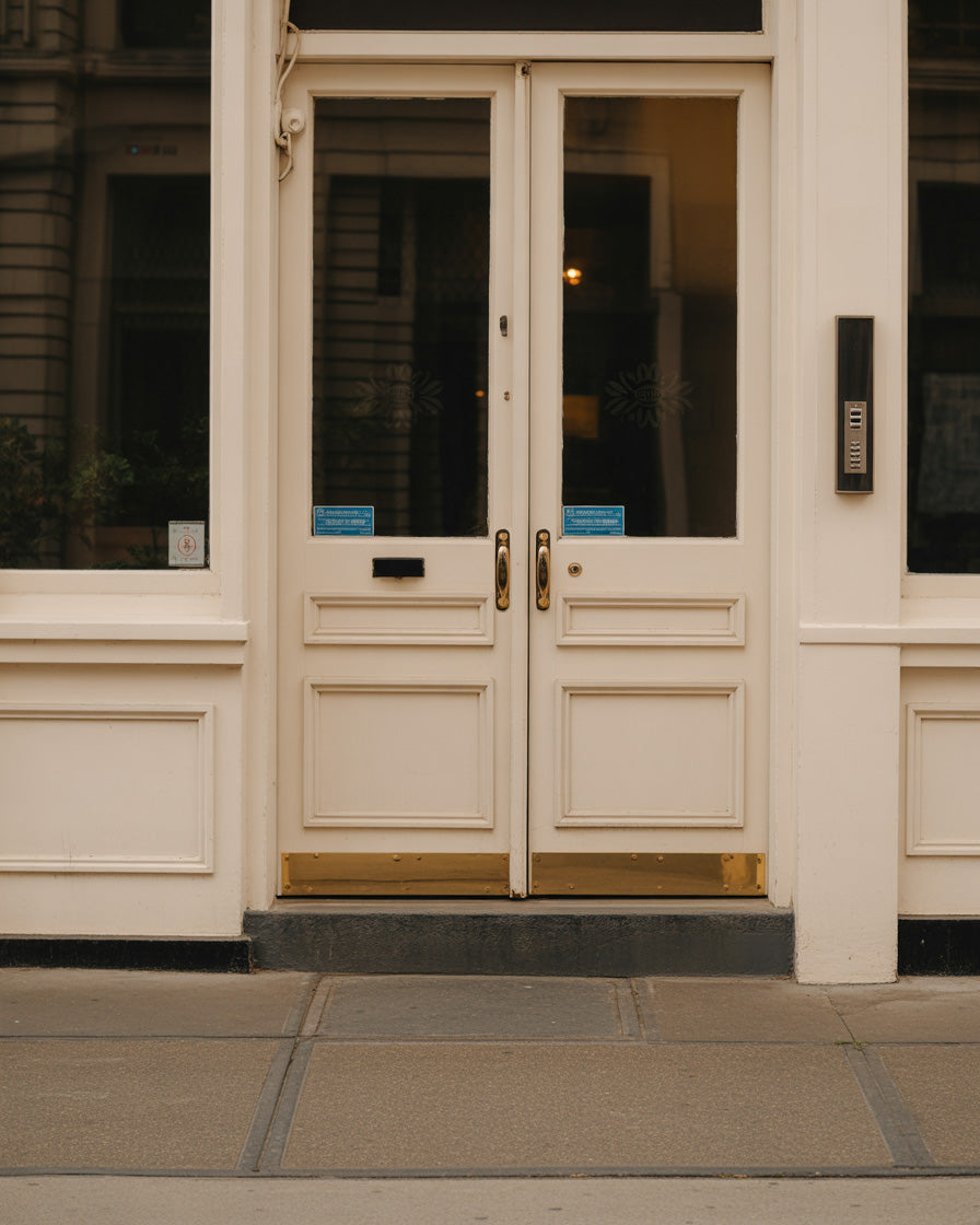 classic white double door with brass accents urban facade
