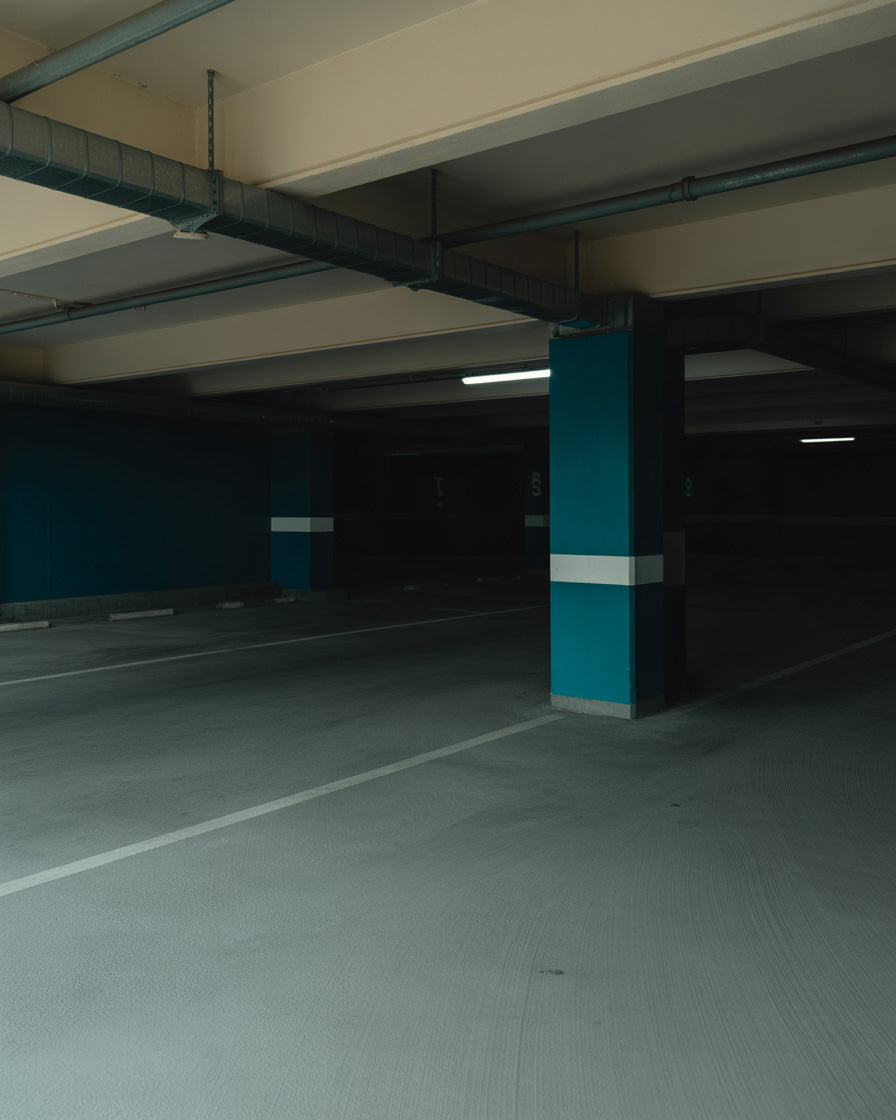 Dim underground parking garage with concrete columns and industrial lighting