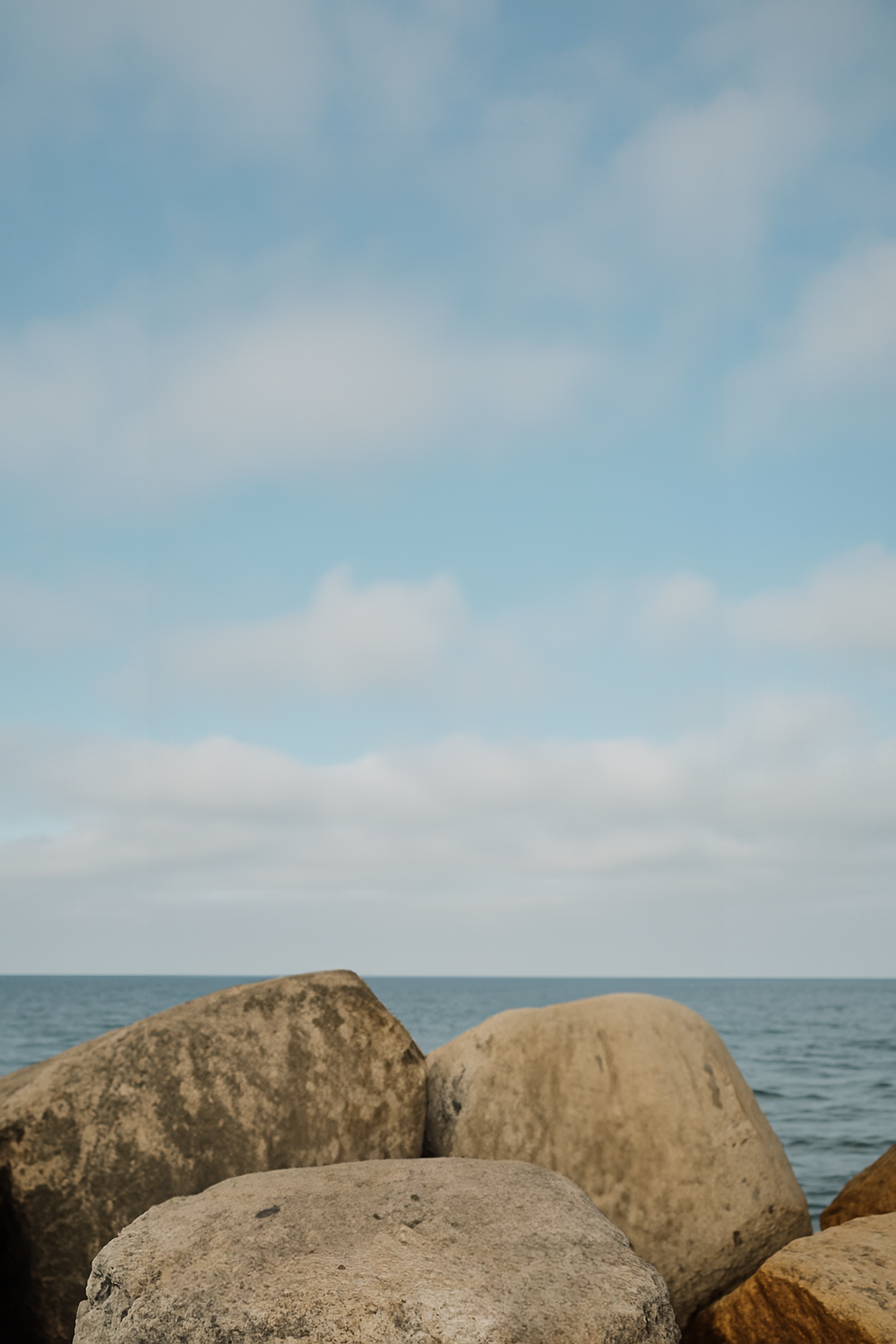 Coastal rocks beneath a wide blue sky